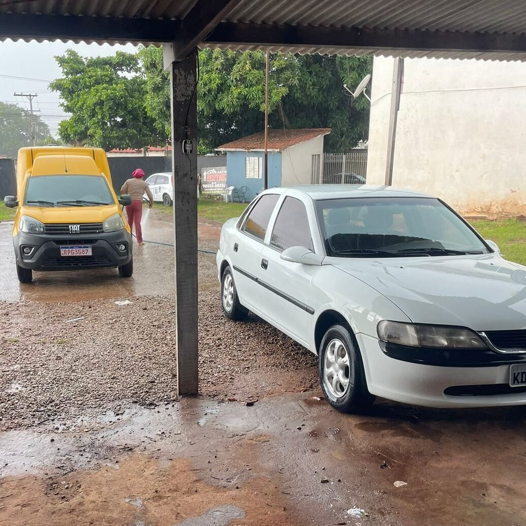 Pátio do Lava Jato Destak em Inhumas com Fiorino dos Correios e Vectra branco durante processo de lavagem